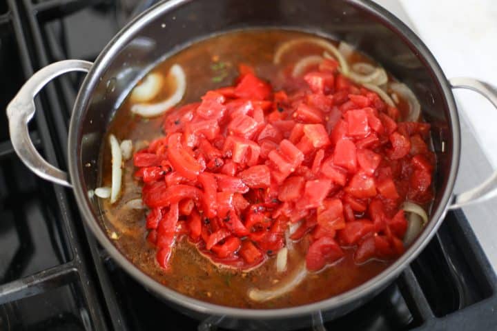 red peppers and diced tomatoes in the pan with onions, garlic and spices.