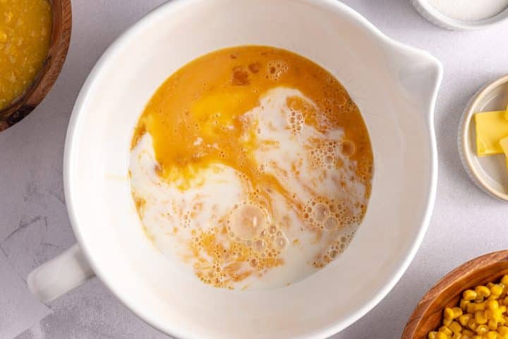 milk egg and sugar in a bowl.