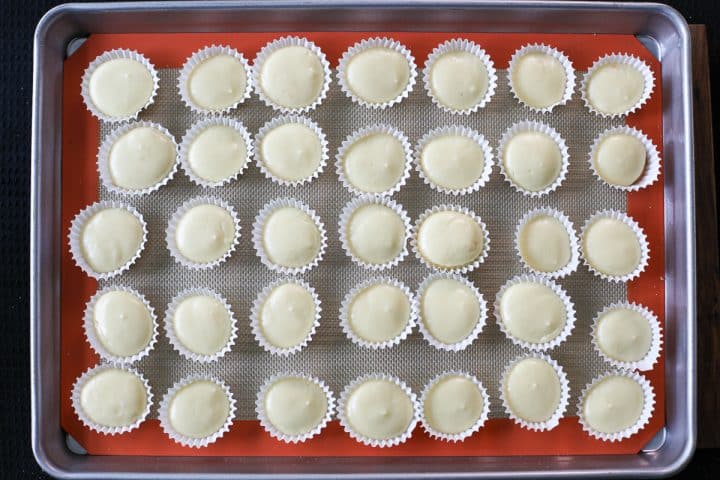 baked mini cheesecakes on a tray.