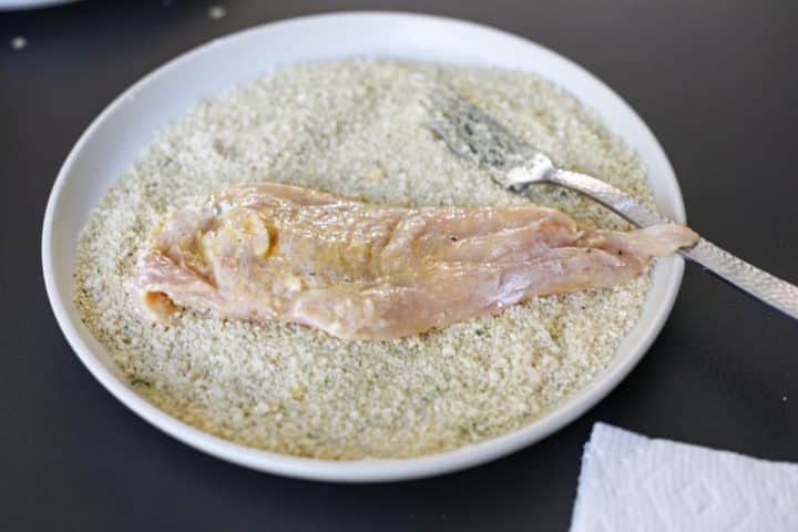 breading a chicken cutlet.