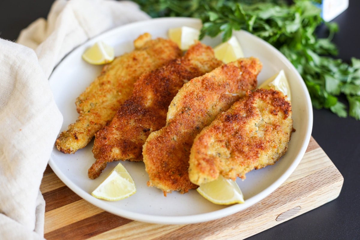 crispy chicken cutlets on a plate with lemon.