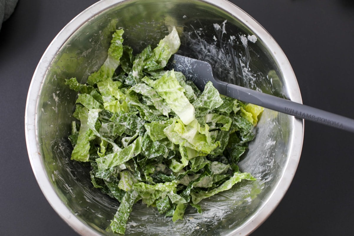 lightly dressed romaine lettuce in a bowl. 