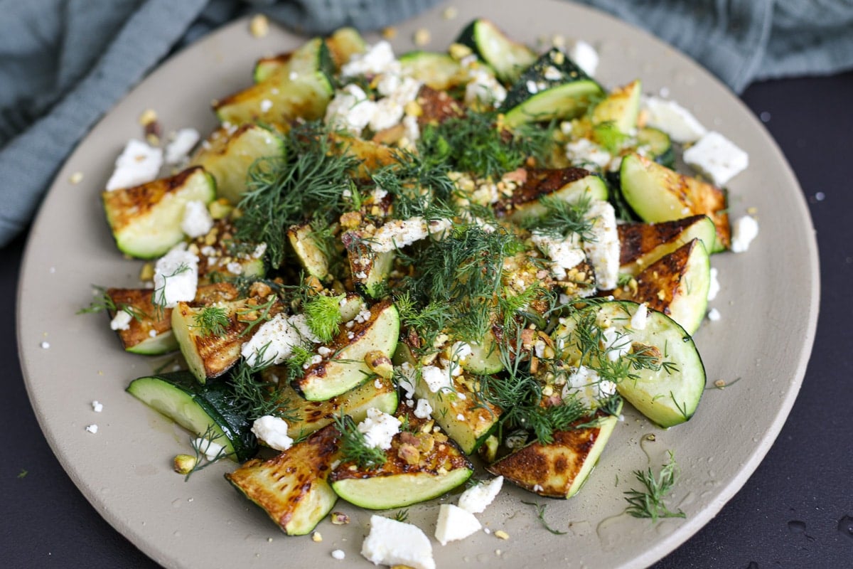 sautéed zucchini on a plate with toppings. 