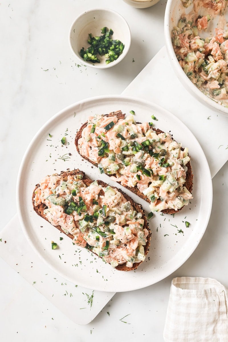 smoked salmon salad on toasted bread with garnishes.