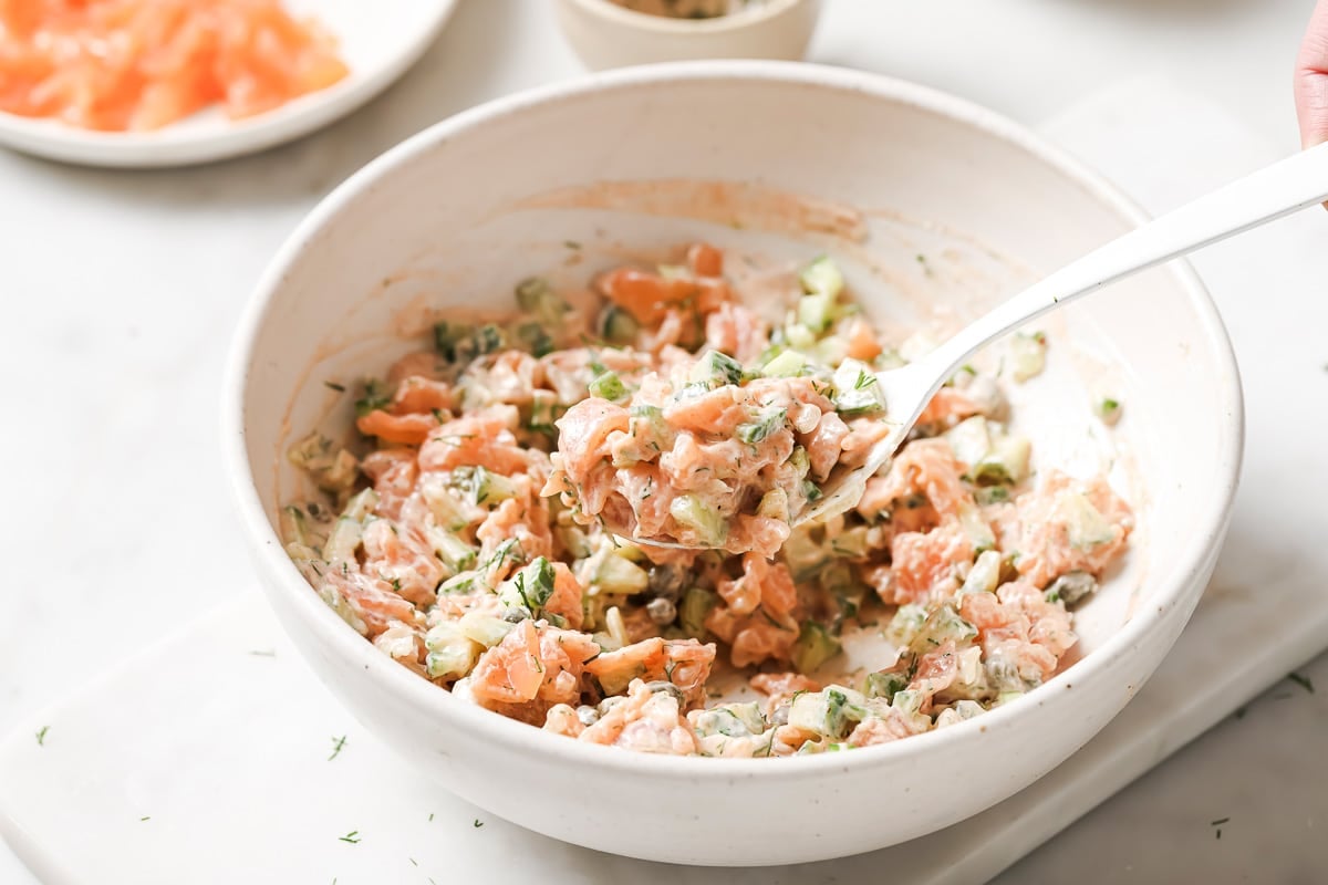 chopped smoked salmon salad in a bowl with a spoon. 
