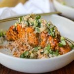 Air Fryer Spicy Hasselback Salmon in bowl with spicy creamy sauce.
