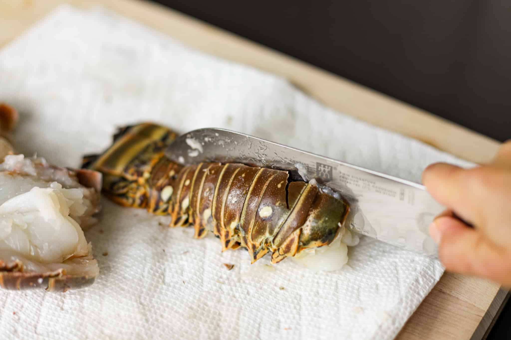 Slicing through the lobster tail with a sharp knife. Grilled Lobster Tails Recipe - Healthyish Foods