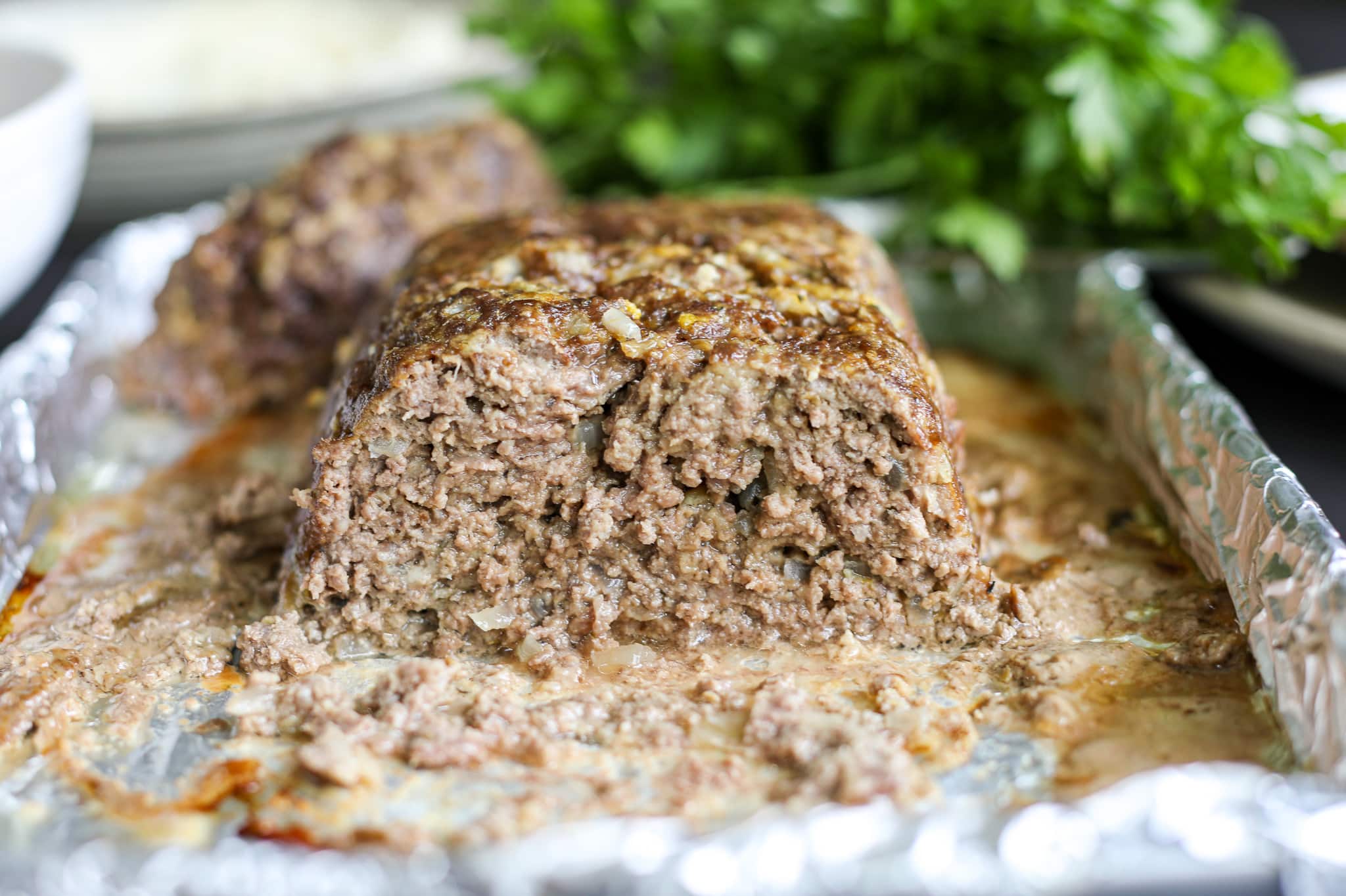 fresh out of the oven meatloaf cut in half so you can see the inside.