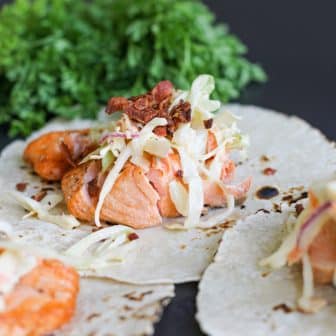 salmon tacos with apple cabbage slaw and crispy bacon.