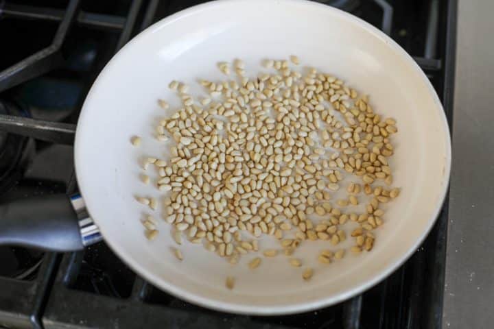 toasting the pine nuts in a pan.