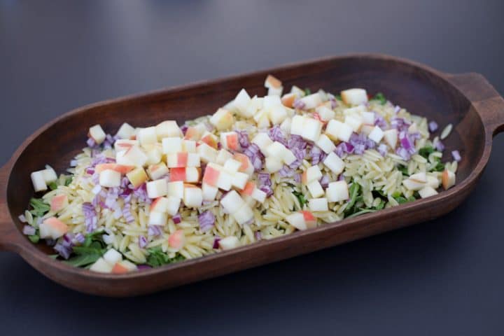 pasta salad with arugula, apples, orzo and red onion. 