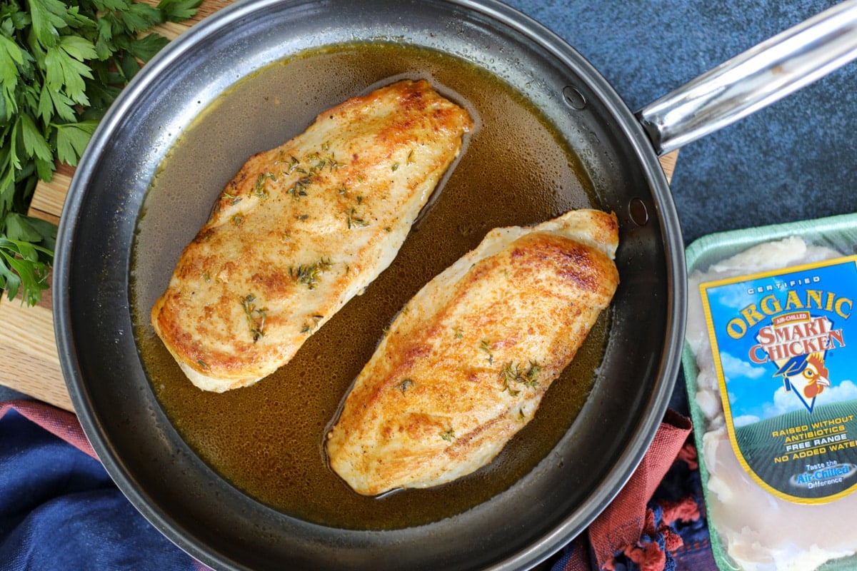 chicken breasts in a pan with smart chicken packaging on the side.