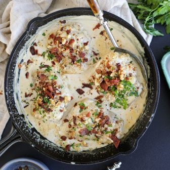 creamy dijon chicken thighs in a pan with bacon and walnuts.