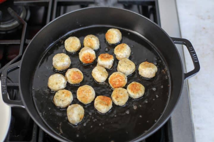 meatballs sautéing in a pan.