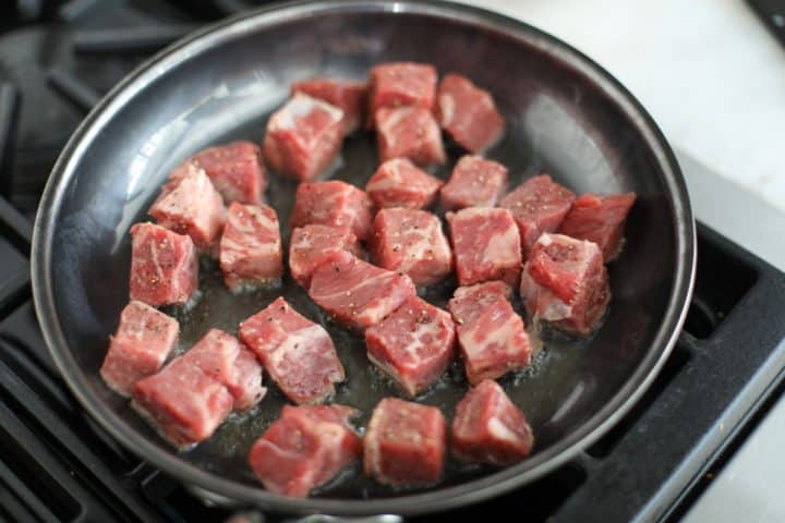 steak bites in a hot pan.