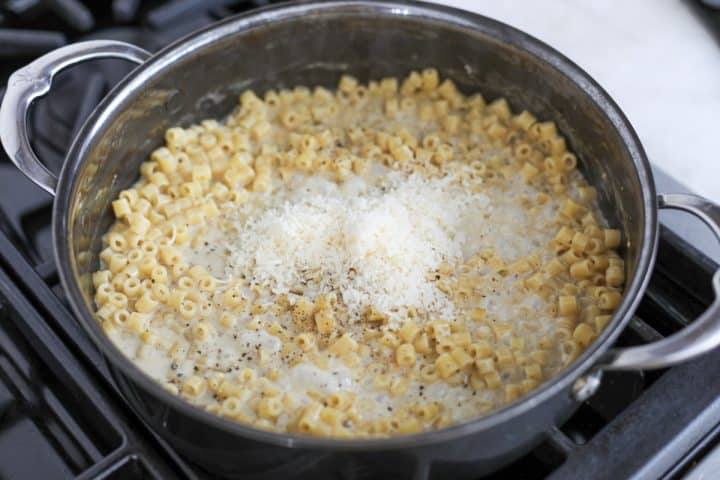 grated parmesan cheese being added to the sauce.