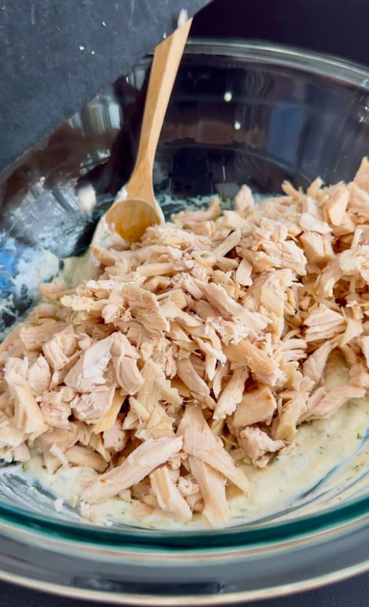 shredded and chopped chicken in a dressing.