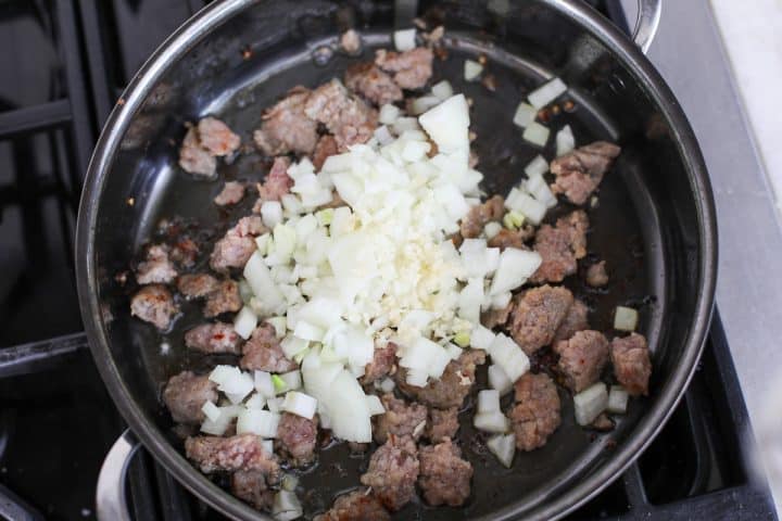 ground sausage in a pan browning with onions and garlic. 