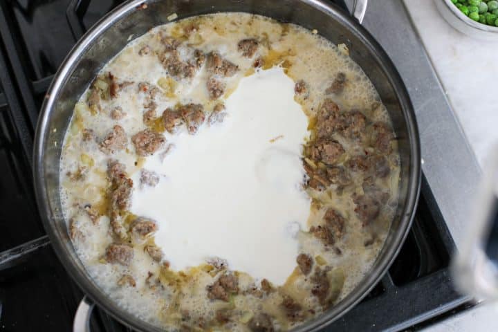 creamy pasta and sausage sauce in a pan. 