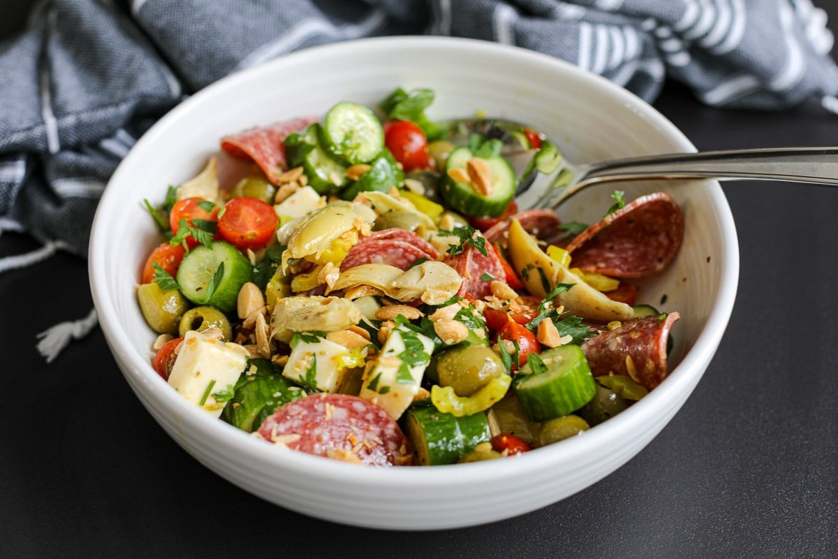 charcuteries salad in a bowl with a spoon.