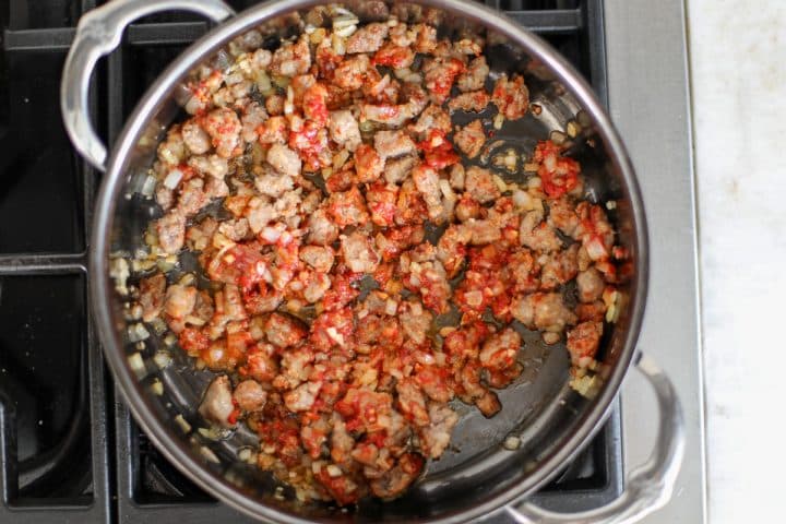 tomato paste and sausage in a hot pan.