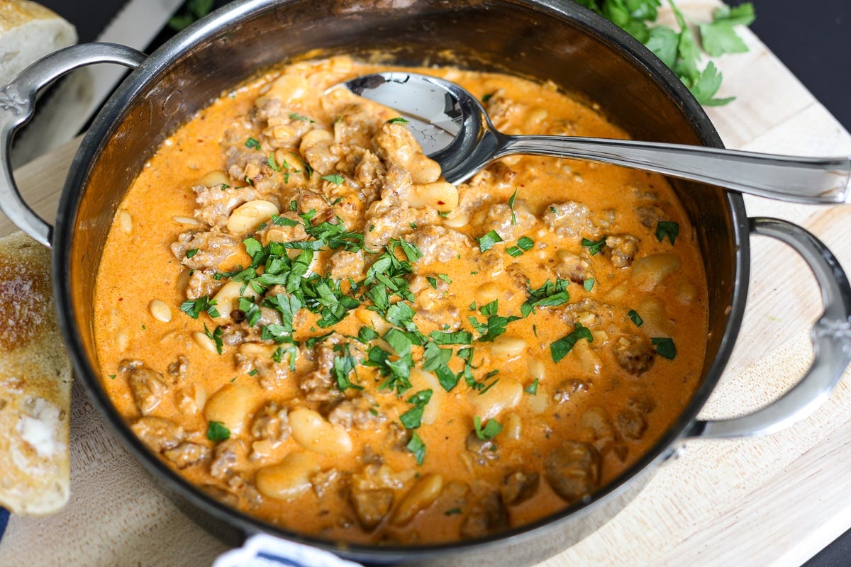 bean and sausage dip in a hot pan.
