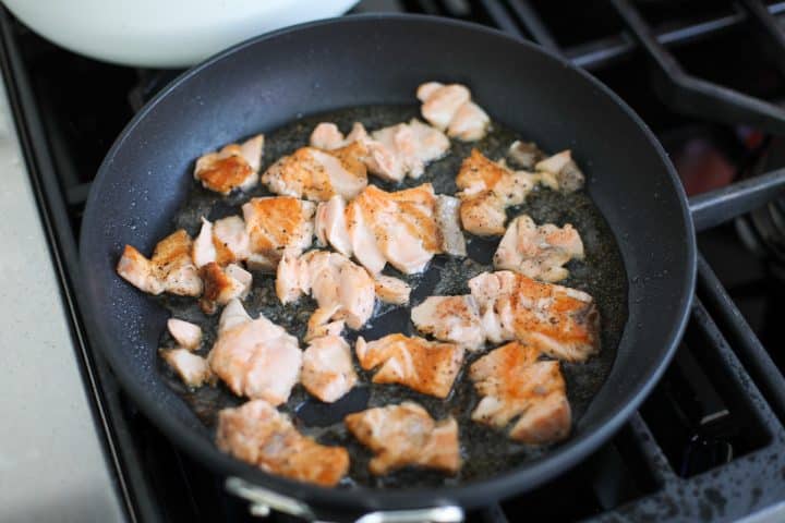 smashed salmon searing in a pan.