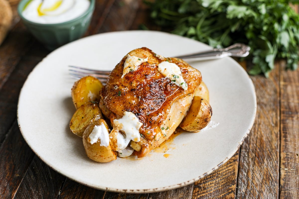 roasted chicken on a plate with potatoes.