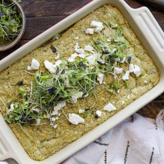 pesto baked eggs with delallo jar next to the baking dish.
