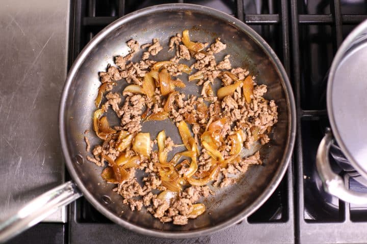beef and caramelized onions in a pan. 