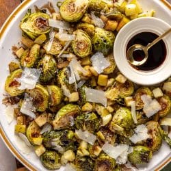 brussels on a plate with parmesan cheese, apples and balsamic glaze.