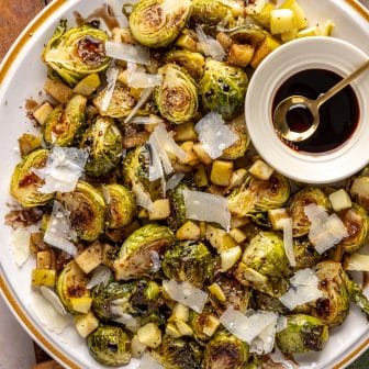 brussels on a plate with parmesan cheese, apples and balsamic glaze.
